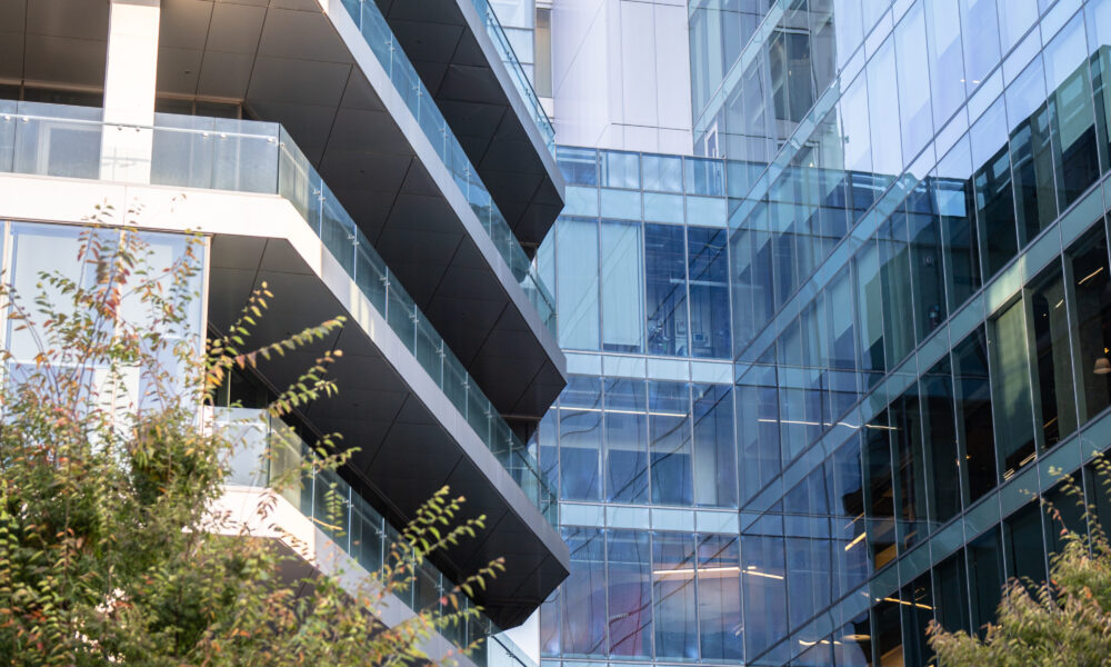 SpaceCo, closer view of google headquarters glass wall building, trees below, google headquarters